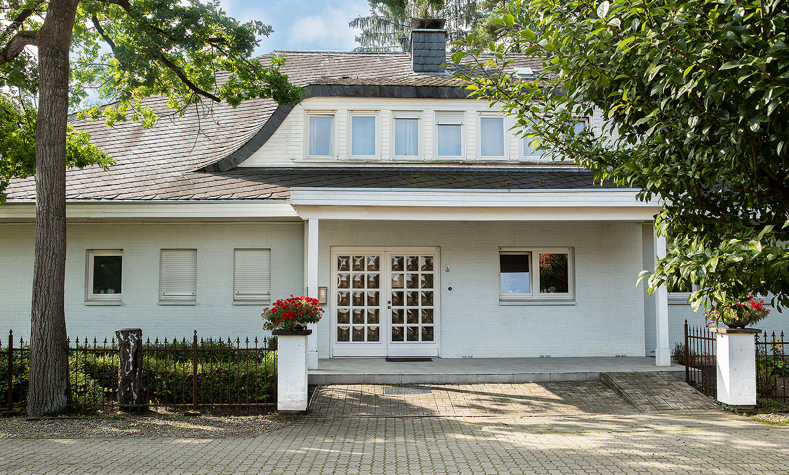 ARCHIMED Pflege-Wohngemeinschaft Waldpark – Eingangsbereich des Hauses mit Blumen vor der Tür